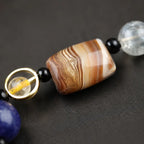 Planet bead tiger eye bracelet close-up highlighting the striped agate centerpiece with polished tiger eye and natural gemstone bead craftsmanship.