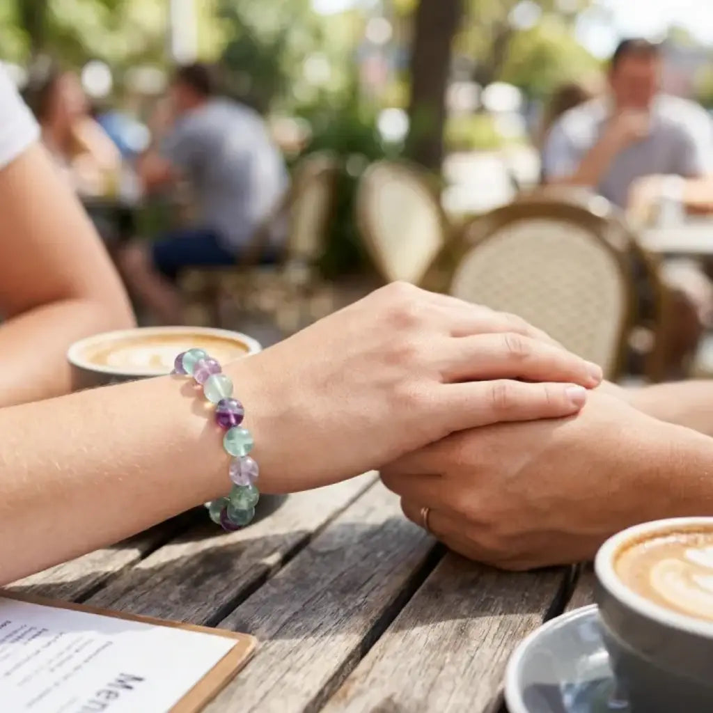 Rainbow Fluorite Crystal Bracelet worn by couple holding hands in cafe, symbolizing love connection and calming emotional energy