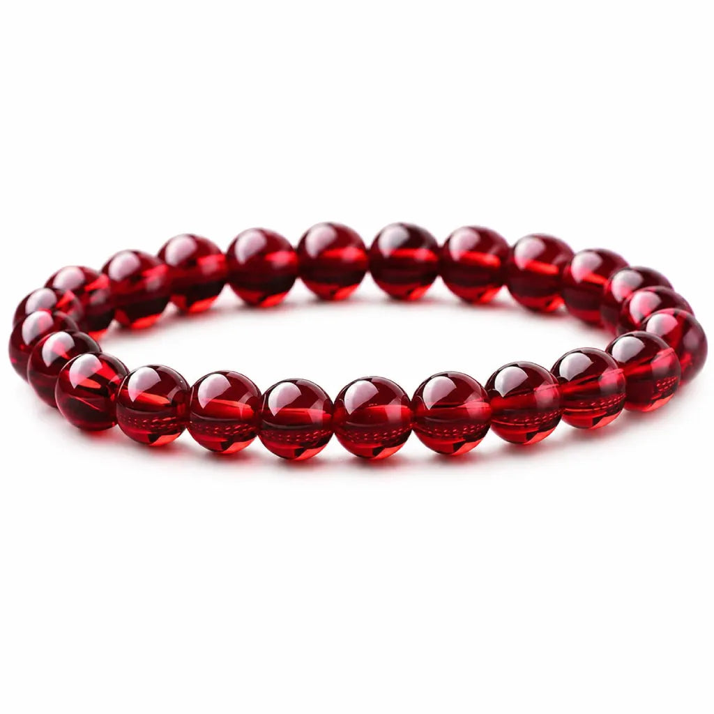 Red garnet jewelry bracelet with polished gemstone beads on white background, elegant crystal accessory for gifting