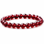 Red garnet jewelry bracelet with polished gemstone beads on white background, elegant crystal accessory for gifting