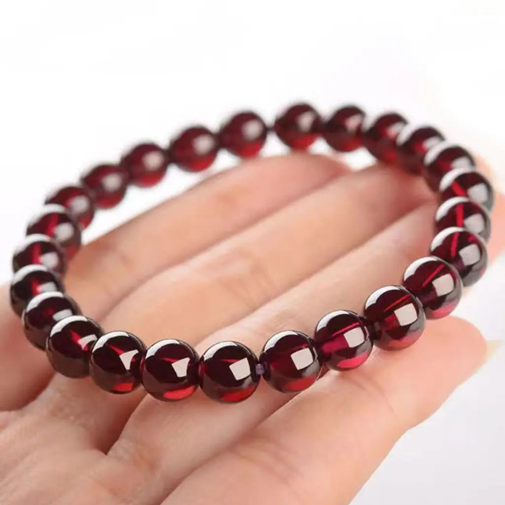 Red garnet jewelry stretch bracelet shown on hand, premium gemstone accessory with comfortable everyday fit