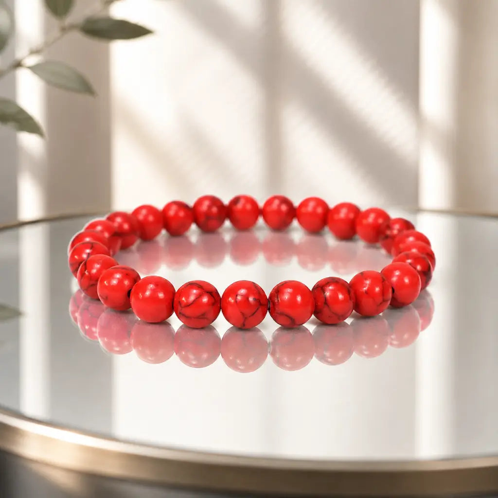 Red howlite bracelet with polished healing crystal beads on white background for versatile jewelry