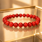 Red howlite bracelet with polished healing stone beads on reflective display for stylish comfort wear