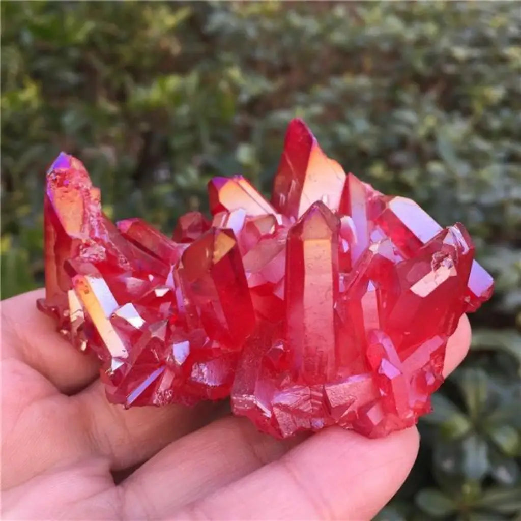 Red quartz crystal cluster displayed in hand with vibrant natural red points, raw mineral specimen for crystal collectors and décor.
