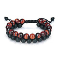 Red tiger eye bracelet with polished red-brown 8 mm beads, textured black lava stone beads, double-layer braided cords, and an adjustable sliding knot on a white studio background.