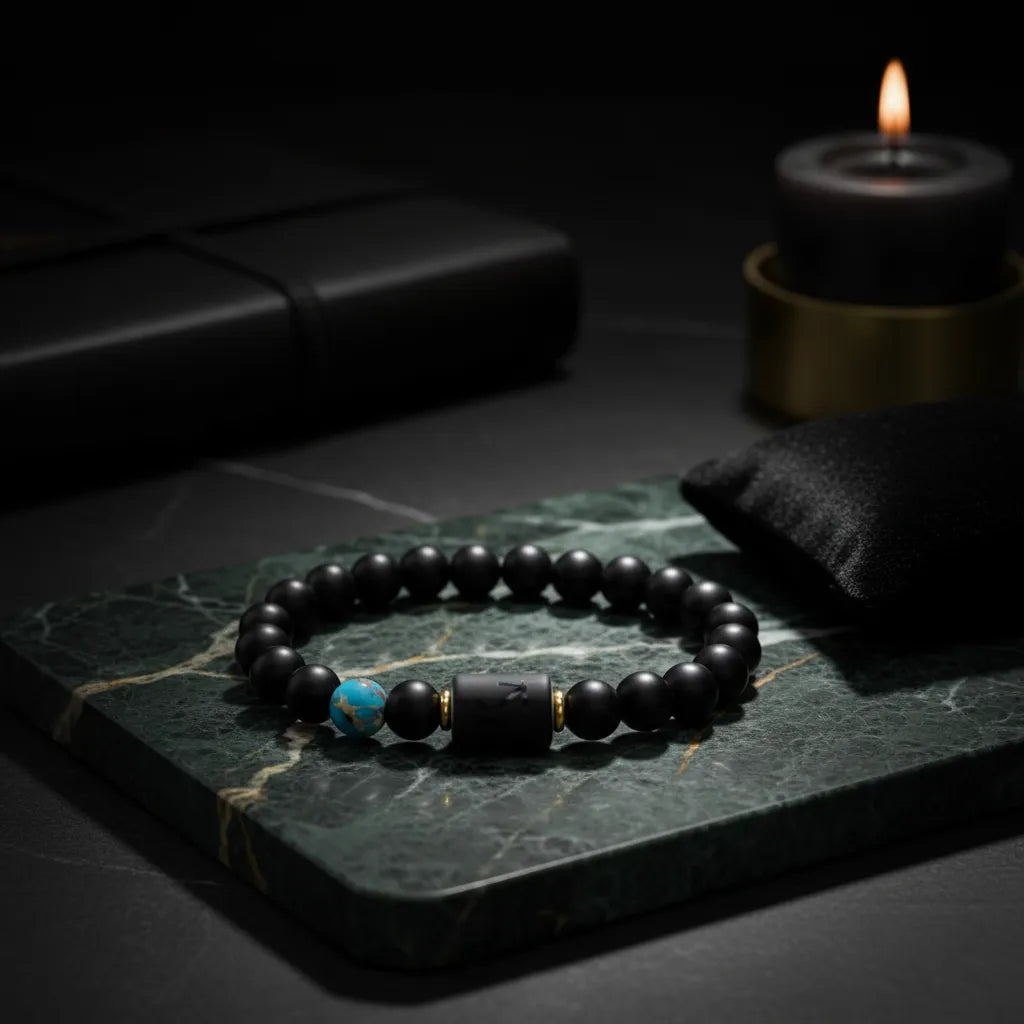 Sagittarius zodiac bracelet displayed on green marble slab with candle and dark ambient lighting for moody aesthetic
