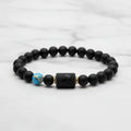 Sagittarius zodiac bracelet close-up on wooden surface highlighting matte black beads and engraved center charm