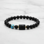 Sagittarius zodiac bracelet close-up on wooden surface highlighting matte black beads and engraved center charm