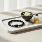 Sagittarius zodiac bracelet on white tray with essential oil bottle and lotus bowl in bright spa-inspired setting