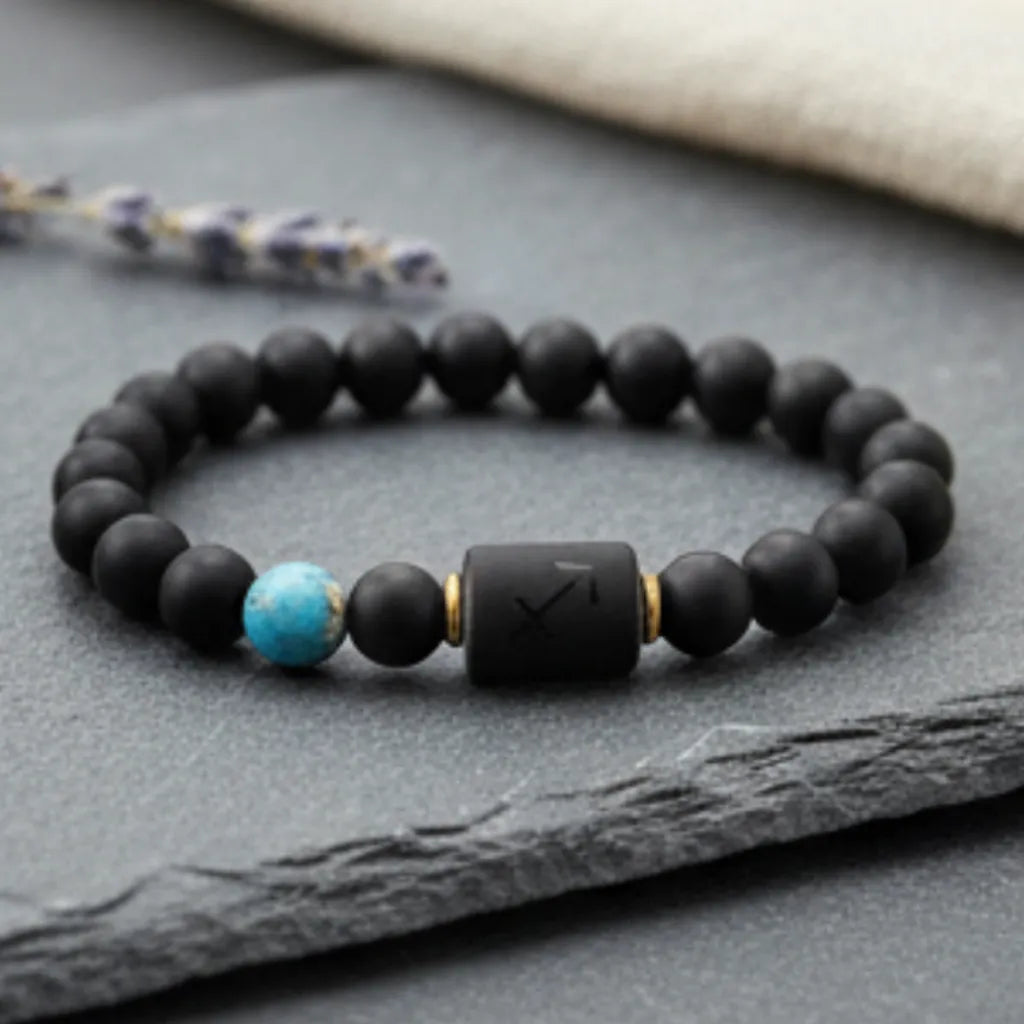Sagittarius zodiac bracelet on black stone with decorative feather and crystal in soft neutral setting