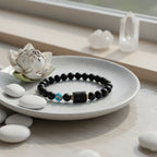 Sagittarius zodiac bracelet resting on ceramic plate with spa stones and lotus flower in calm wellness setting