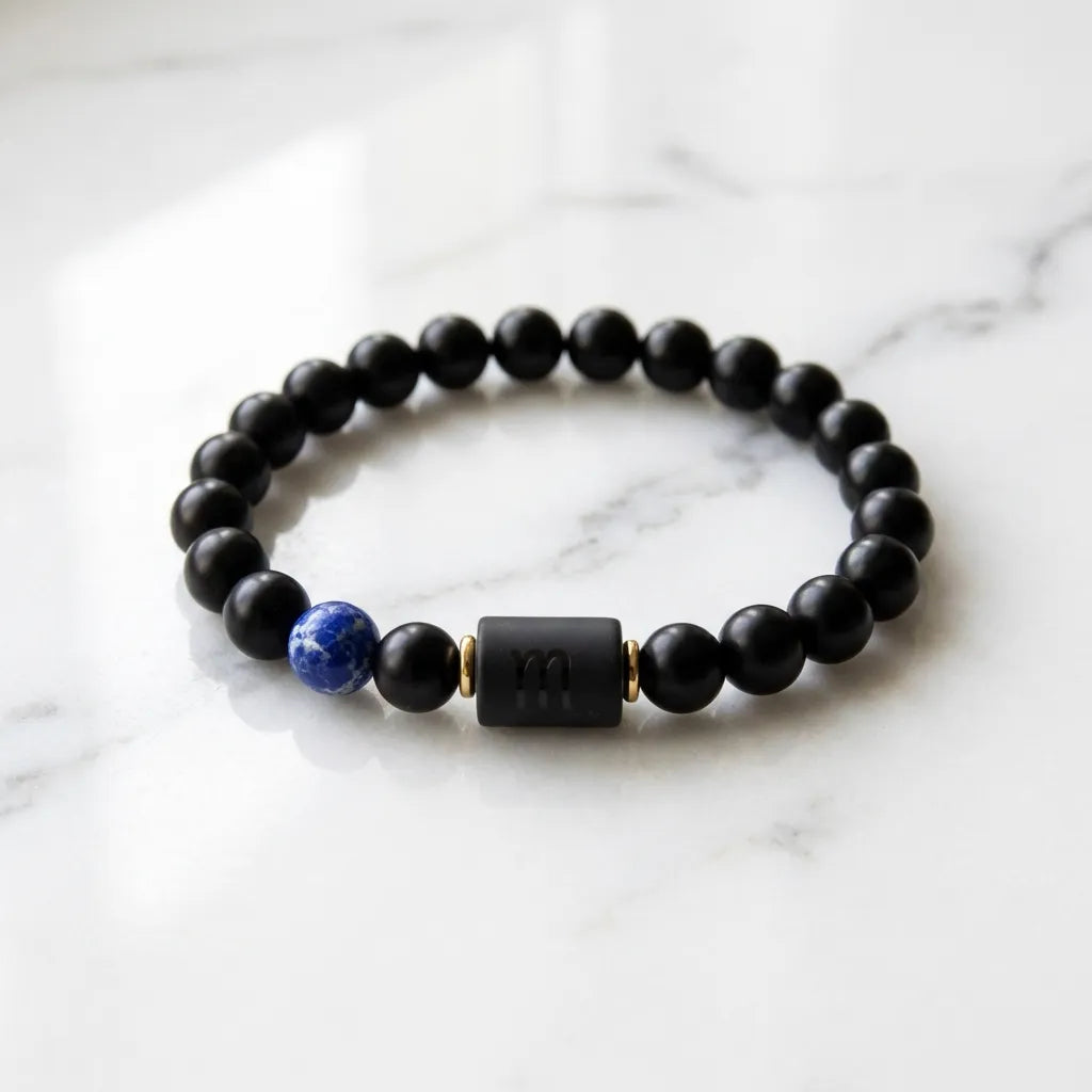 Scorpio Zodiac Bracelet on marble surface with black beads and blue stone, elegant astrology accessory for stylish everyday wear