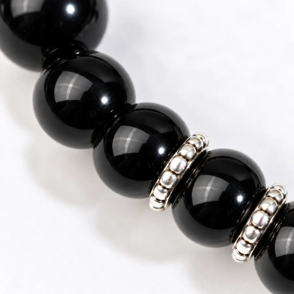 Shadow guardian obsidian bracelet close-up showing polished black beads and silver spacer details for a refined jewelry finish.