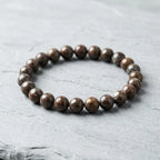 Snoflake bracelet brown speckled jasper beads on clean white fabric, simple crystal jewelry for daily balance