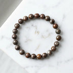 Snoflake bracelet polished brown jasper beads on white marble, elegant gemstone accessory for refined daily wear