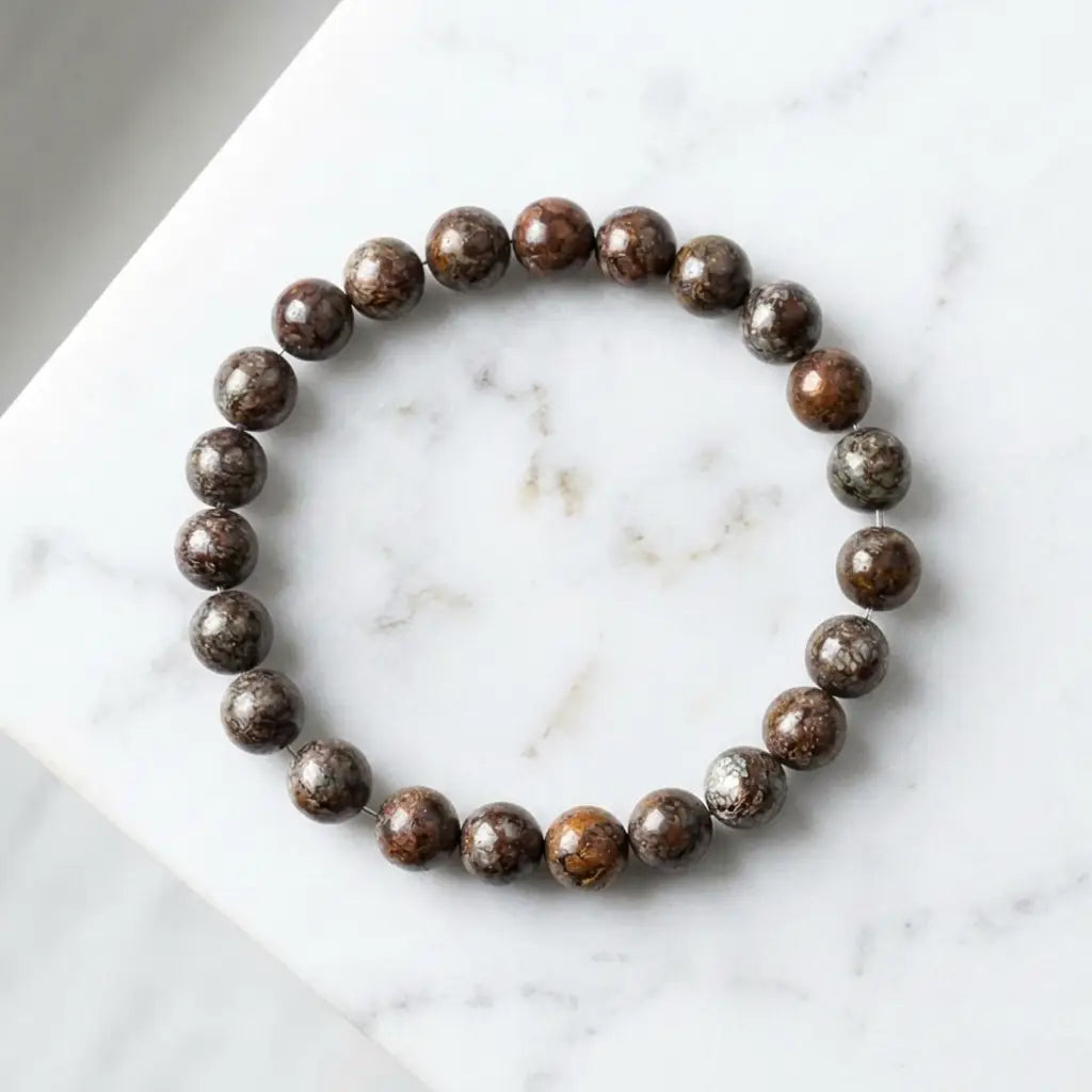 Snoflake bracelet polished brown jasper beads on white marble, elegant gemstone accessory for refined daily wear