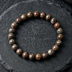 Text: Snoflake bracelet glossy brown stone beads on dark slate, premium gemstone jewelry for modern grounding style
