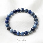 Sodalite stone bracelet blue round bead stretch bracelet on white fabric, calming crystal jewelry for mindful style