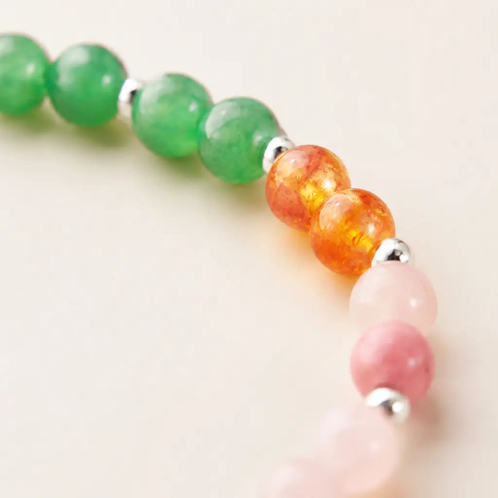 Taurus crystal bracelet close up showing green and orange gemstone beads with handcrafted zodiac jewelry detailing