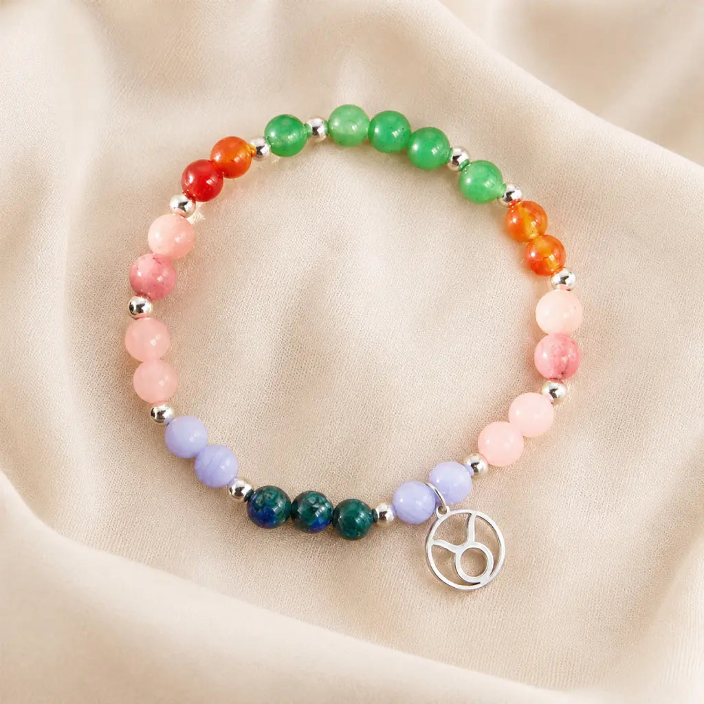 Taurus crystal bracelet presented on soft fabric with colorful gemstone beads and elegant astrology jewelry appeal