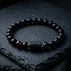 Taurus Zodiac Bracelet on slate stone with matte black beads and red tiger eye, professional astrology jewelry for stability focus and calm energy