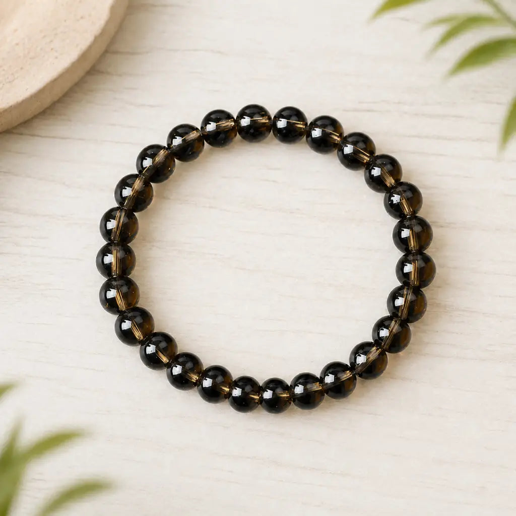 Tea crystal bracelet glossy brown bead bracelet on pale wood with leafy accents, polished crystal jewelry gift