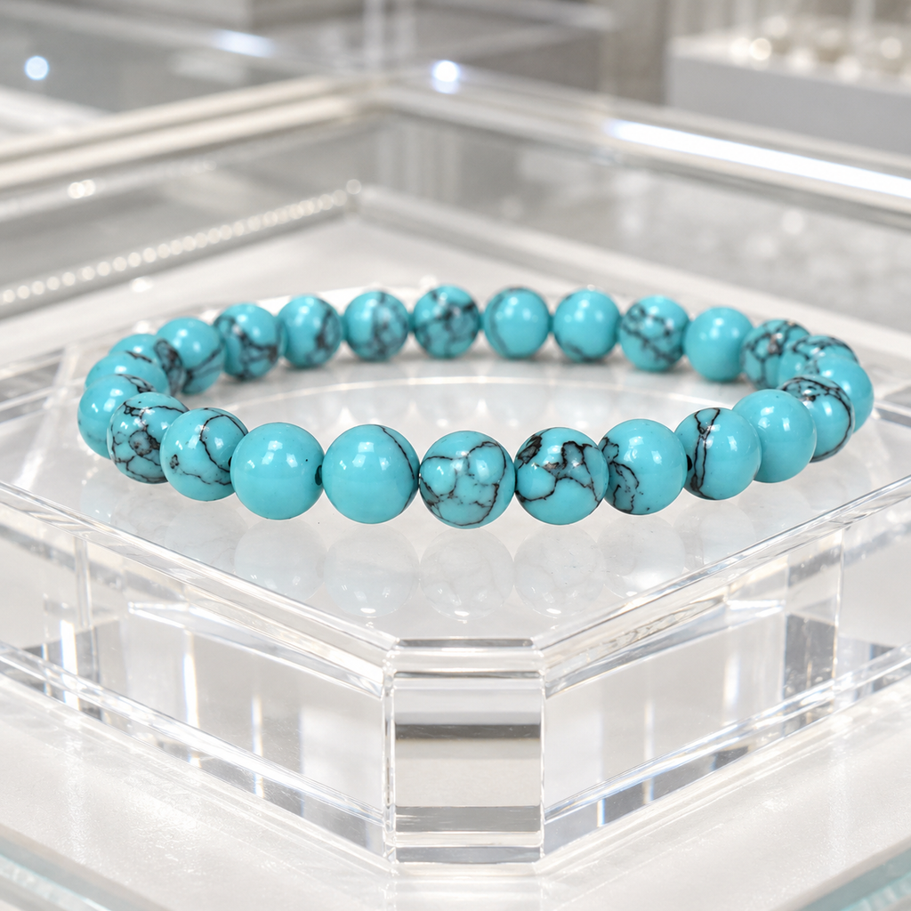 Teal howlite bracelet with polished gemstone beads displayed on a crystal stand for elegant jewelry appeal