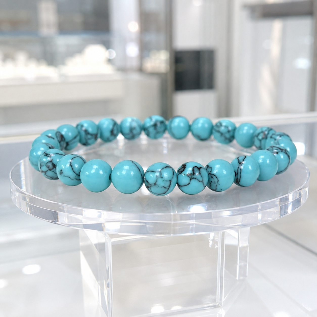 Teal howlite bracelet featuring polished gemstone beads on a clear stand for refined crystal style wear