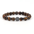 Tiger eye bracelet with glossy brown-gold 8mm round beads, four dark spacer rings, and a round tree-design focal bead, shown in a clean full front view on a plain white background.