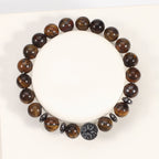 Tiger eye bracelet with glossy brown gold 8mm round beads, four dark spacer rings, and a round tree-design focal bead, seen from above on a white jewelry display form in full view.