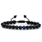 Tiger eye couple bracelets shown in a slim black and deep-blue bead style with polished round accents, matte black beads, and a black adjustable braided cord for direct comparison.