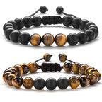 Tiger eye couple bracelets displayed as two coordinated strands with golden-brown tiger eye beads, matte black round beads, and adjustable black braided cords in one complete view.