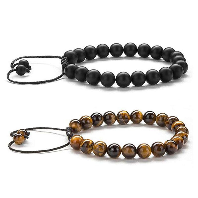 Tiger eye couple bracelets shown as two separate adjustable strands, one matte black and one golden-brown with black accent beads and braided cord ends on a clean white background.