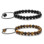 Tiger eye couple bracelets shown as two separate adjustable strands, one matte black and one golden-brown with black accent beads and braided cord ends on a clean white background.
