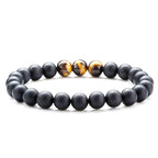 Tiger eye couple bracelets shown in a polished round-bead strand with matte black beads and three golden-brown striped accents centered across the front for easy visual comparison.