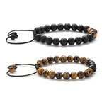 Tiger eye couple bracelets displayed as two separate adjustable strands, one golden-brown and one matte black with warm accent beads and braided cords for couples or close friends.
