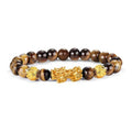 Tiger Eye Pixiu bracelet with golden-brown chatoyant beads and a gold Pixiu charm on white background