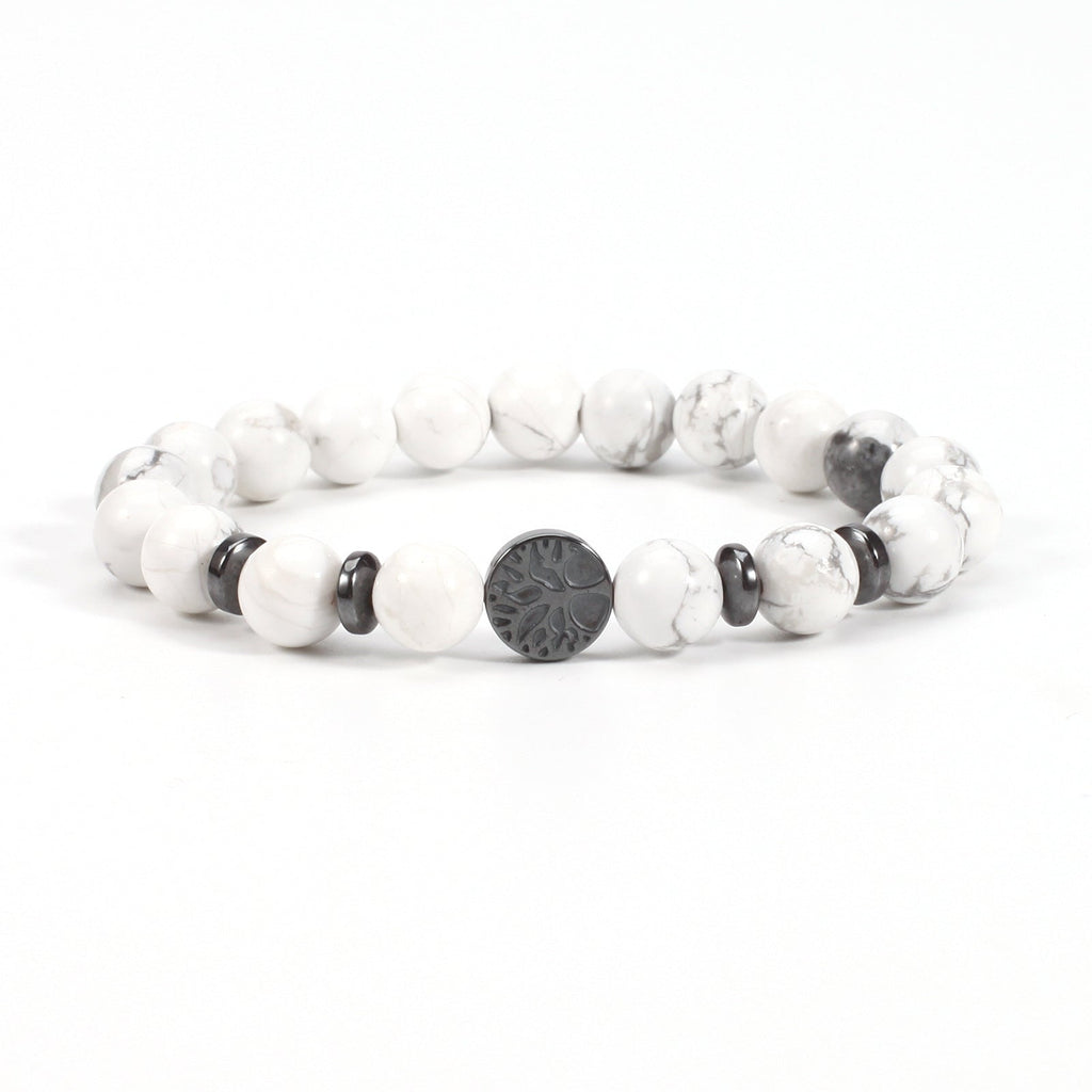 Tree of life stone bracelet in the White Turquoise option, showing white and gray-veined 8mm beads, black spacer rings, and a round dark tree-design focal bead on a white backdrop.