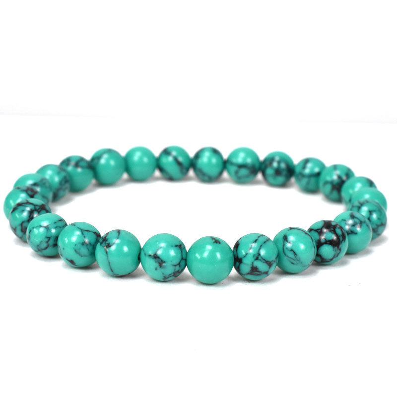Turquoise howlite bracelet with polished 8mm round beads, dark natural style veining and a plain stretch design, photographed in a circular arrangement on a clean white background.