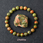 Unakite bracelet with green and pink beads beside a natural raw Unakite stone
