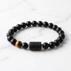 Virgo zodiac bracelet on white marble with black beads and tiger eye accent for clean minimalist product display appeal