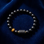 Virgo zodiac bracelet on deep blue fabric with black beads and tiger eye detail for elegant refined astrology jewelry style