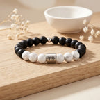 Virgo zodiac bracelet displayed on wood tray with white howlite, black onyx beads and silver charm, gift ready
