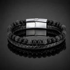 Volcanic Rock bracelet with braided leather and lava stone beads on reflective black display for modern style