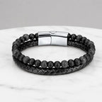 Volcanic Rock bracelet featuring matte black beads and braided leather on marble for sleek daily wear