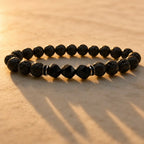 Volcanic stone bracelet in golden light with lava rock beads, black facets and silver spacers for warm style energy