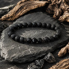 Volcanic stone bracelet on rugged slate with lava rock beads, black faceted accents and earthy driftwood decor