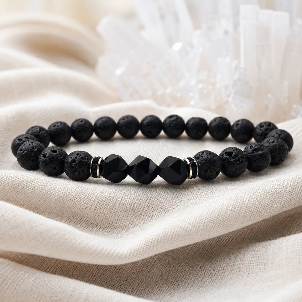 Volcanic stone bracelet on cream linen with black lava beads, faceted center stones and serene crystal display