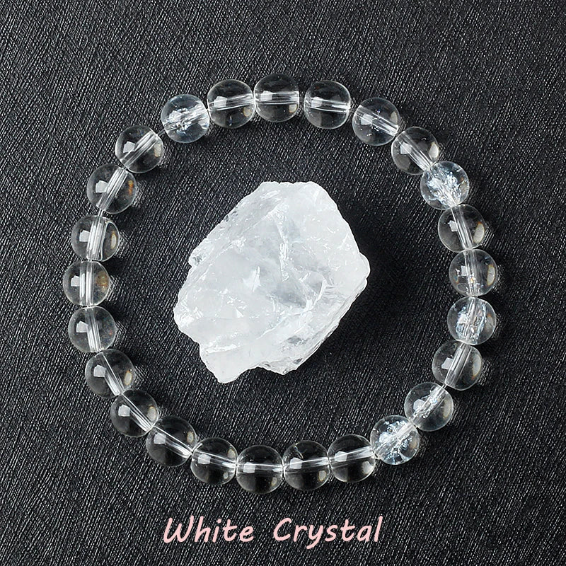 White Crystal bracelet with clear polished quartz beads surrounding a raw white quartz specimen on dark background