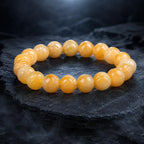 Yellow jade quartz bracelet displayed on dark stone featuring natural crystal beads for elegant energy appeal
